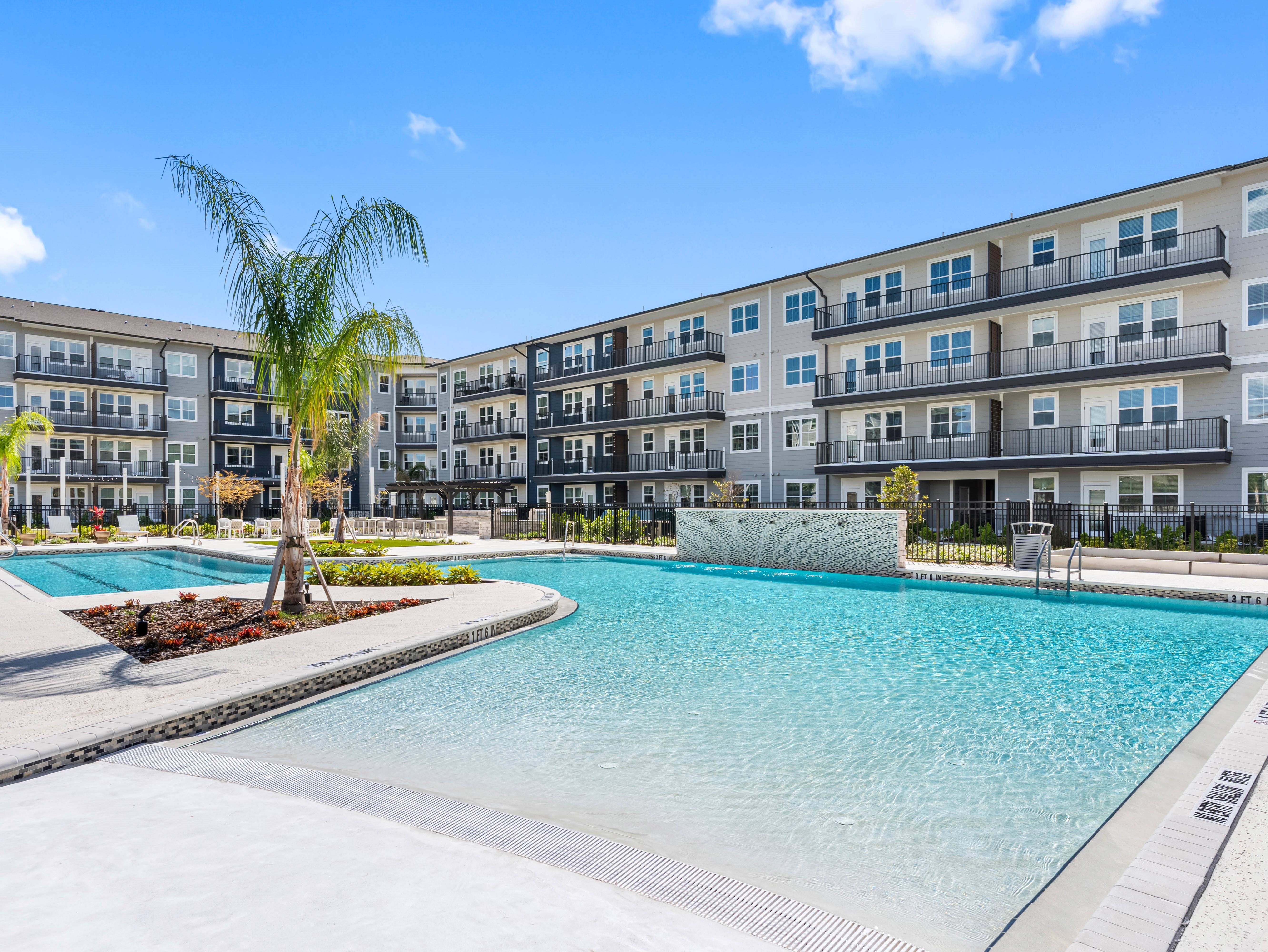 A swimming pool in front of apartment buildings.